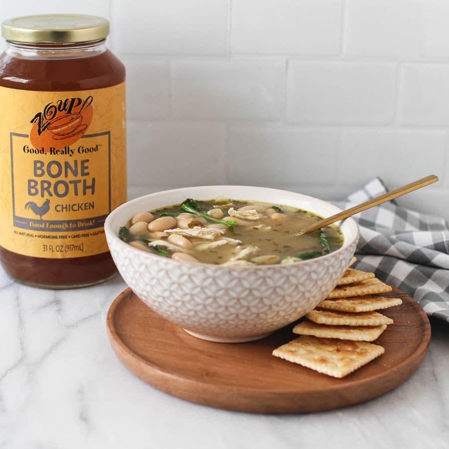 chicken soup with crackers and Zoup! chicken bone broth jar on kitchen counter platter
